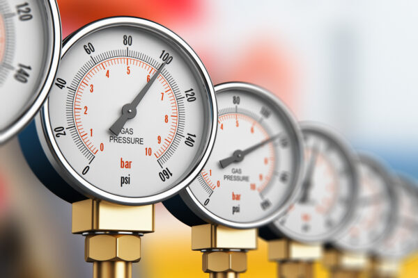 Creative abstract oil and gas fuel manufacturing industry business concept: 3D render illustration of the row of metal steel high pressure gauge meters or manometers with brass fittings on tubing pipeline at LNG or LPG natural gas distribution station plant or factory facility with selective focus effect